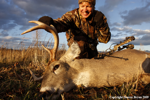 Bowhunter with whitetail buck kill.