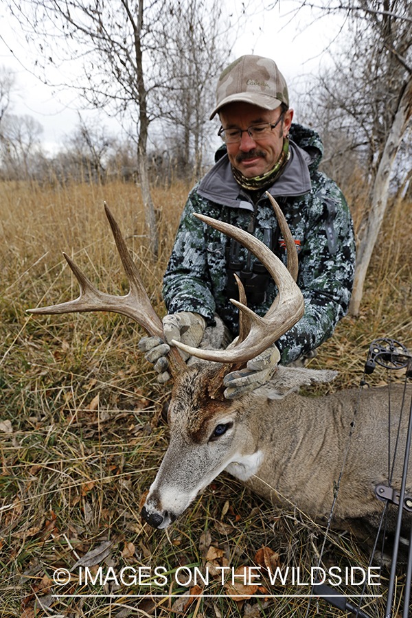 Bowhunter with bagged white-tailed buck.