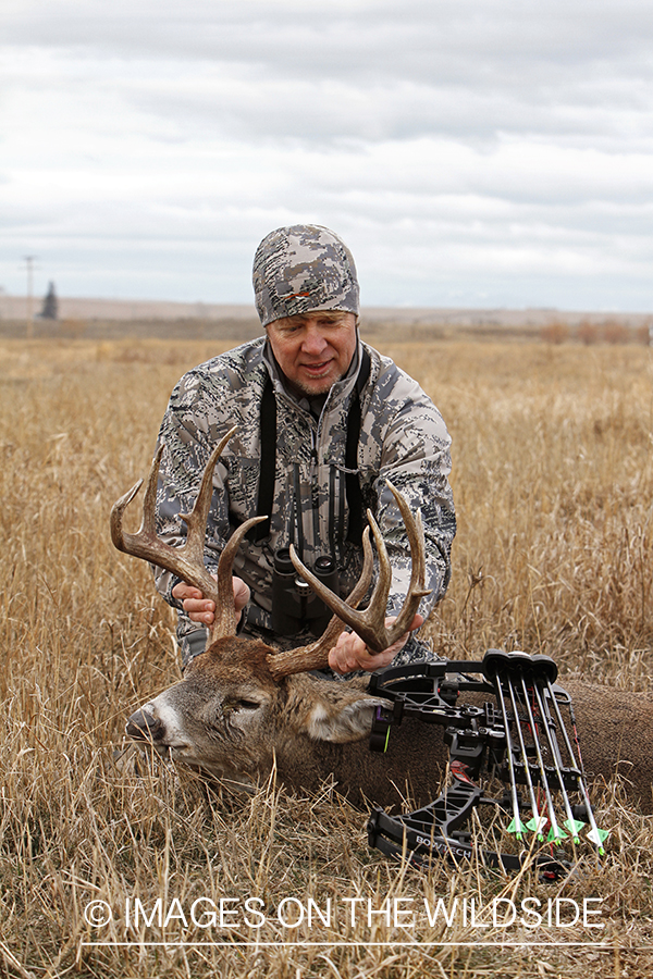 Bowhunter with downed white-tailed buck.