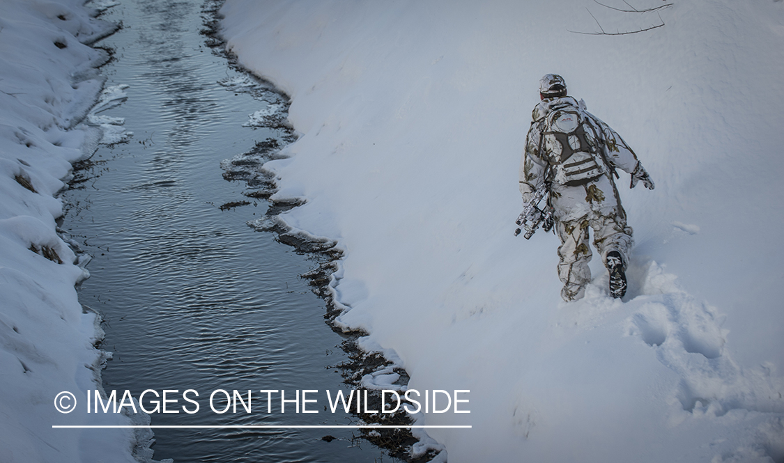 Bowhunter in winter landscape.