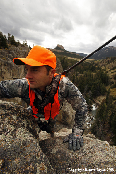 Rifle hunter climbing rocks