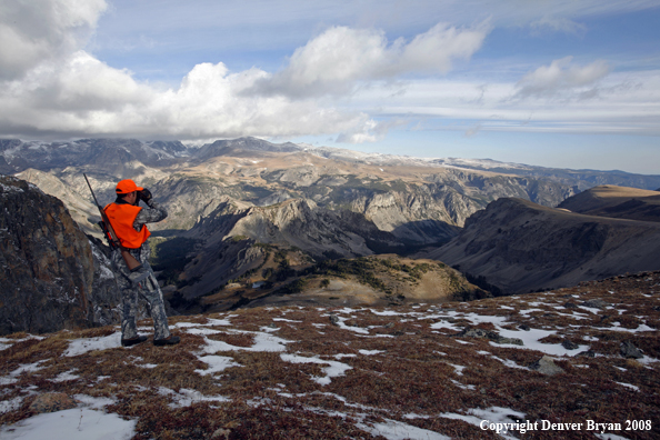 Rifle hunter scouting for big game over Beartooth Pass
