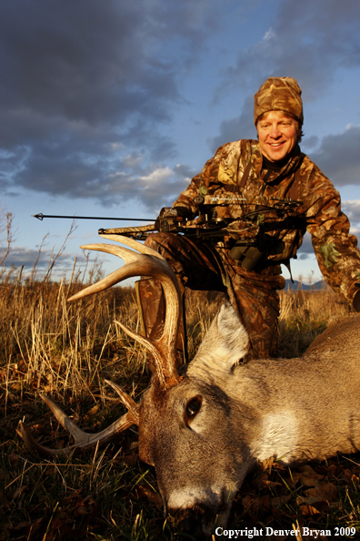 Bowhunter with whitetail buck kill.