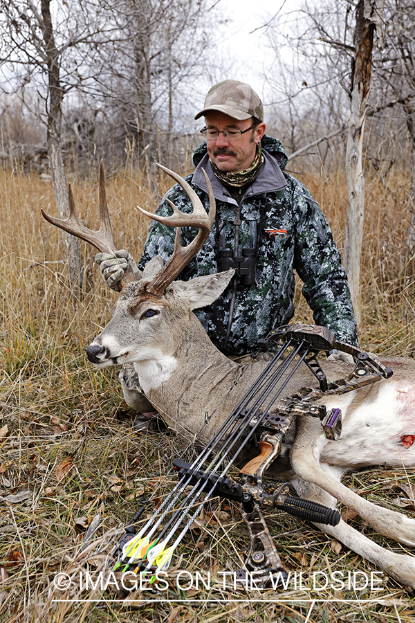Bowhunter with bagged white-tailed buck.