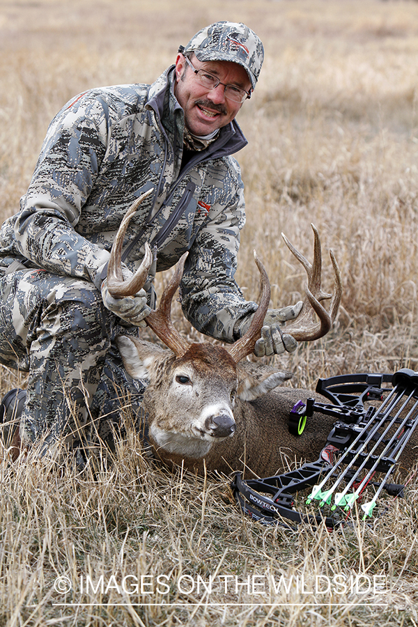 Bowhunter with downed white-tailed buck.