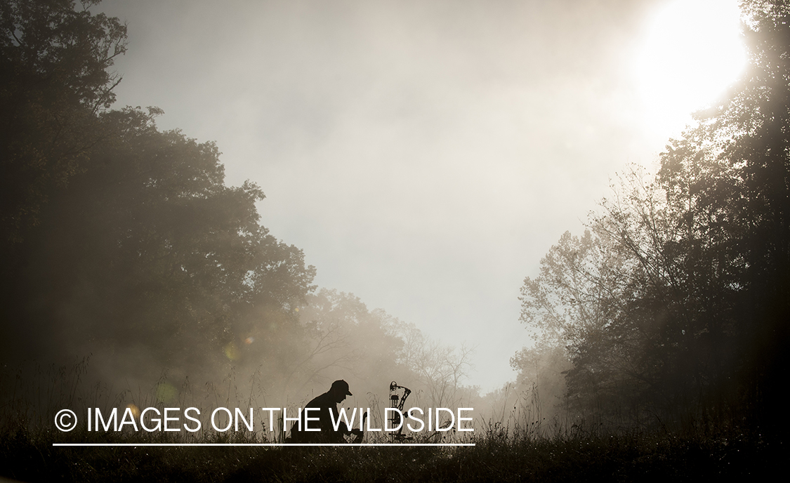Bowhunter in fall forest.