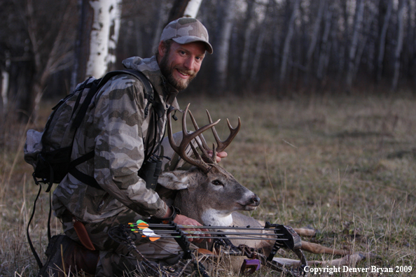 Bowhunter with bagged whitetail buck.