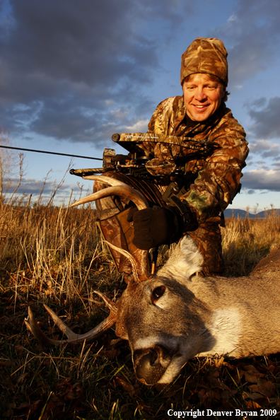 Bowhunter with whitetail buck kill.