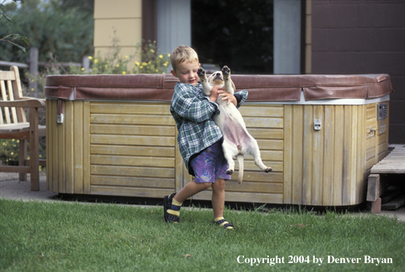 Child with yellow Labrador Retriever puppy