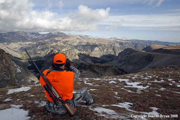 Rifle hunter scouting for big game over Beartooth Pass
