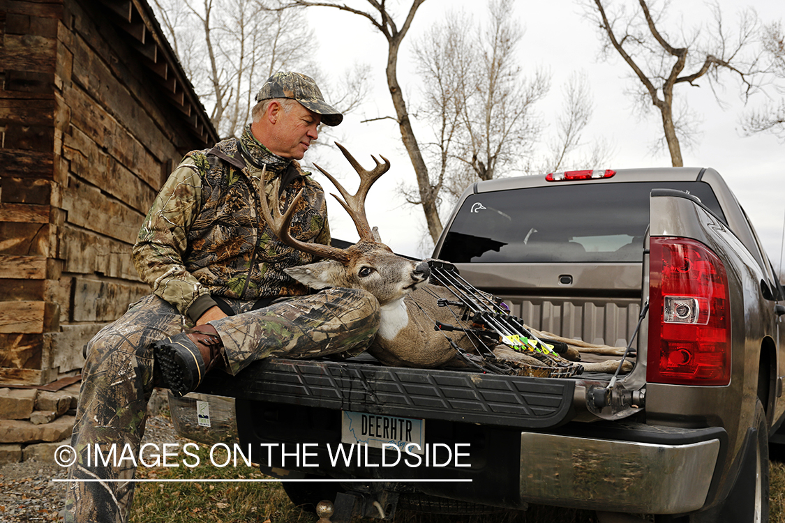 Bowhunter with bagged white-tailed buck.