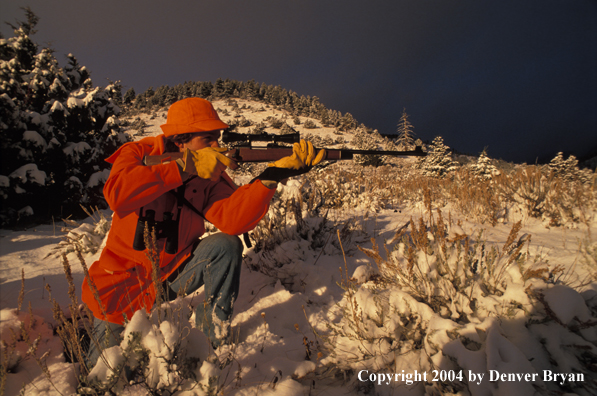 Big game hunter aiming/shooting.