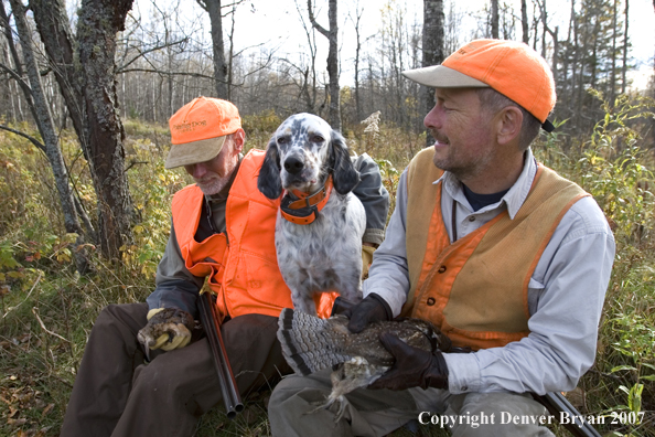 Upland bird hunters sitting with English Setter and retrieved woodcock and grouse.