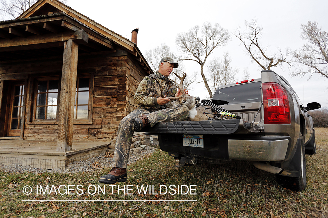 Bowhunter with bagged white-tailed buck.