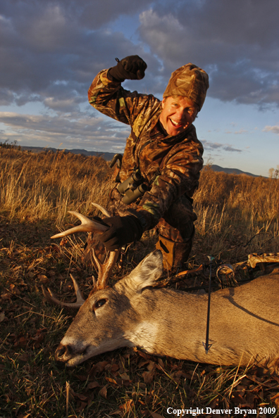 Bowhunter with whitetail buck kill.