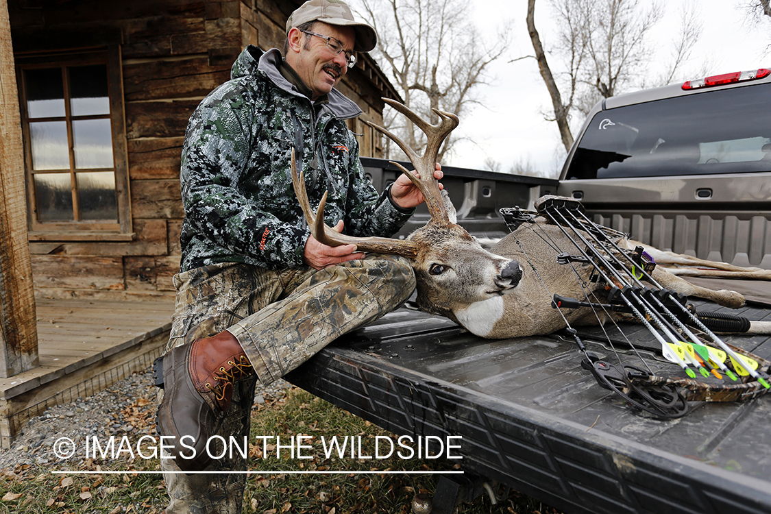 Bowhunter with bagged white-tailed buck.