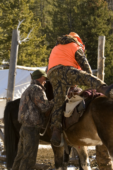 Elk hunter mounting horse 
