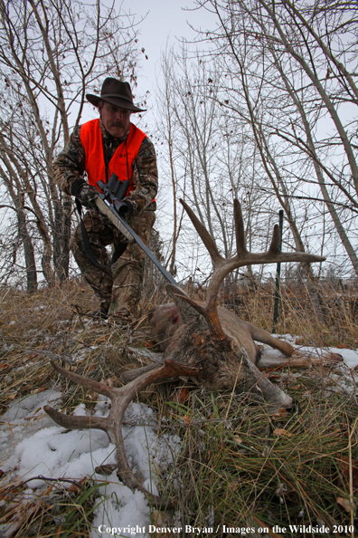 Hunter approaching downed buck. 
