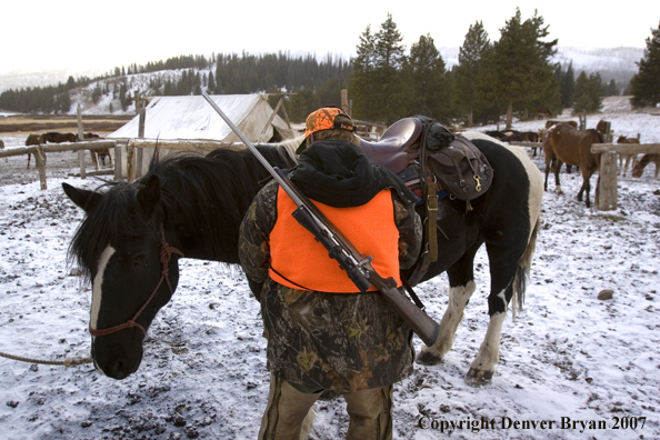 Elk hunter getting horse ready to ride out