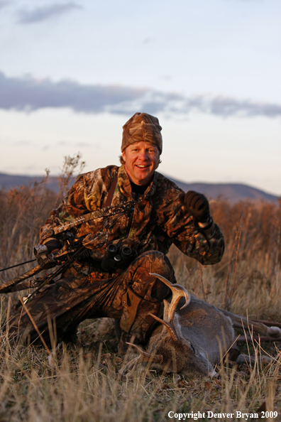 Bowhunter with whitetail buck kill.