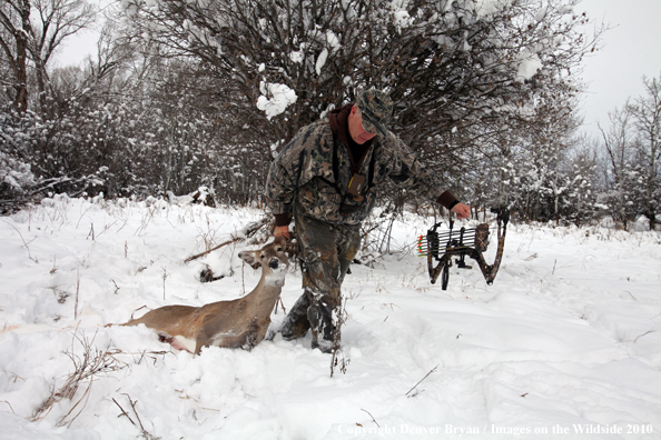 Archery hunter with bagged white-tailed doe. 