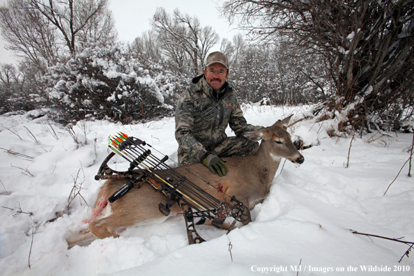 Archery hunter with bagged white-tailed doe. 