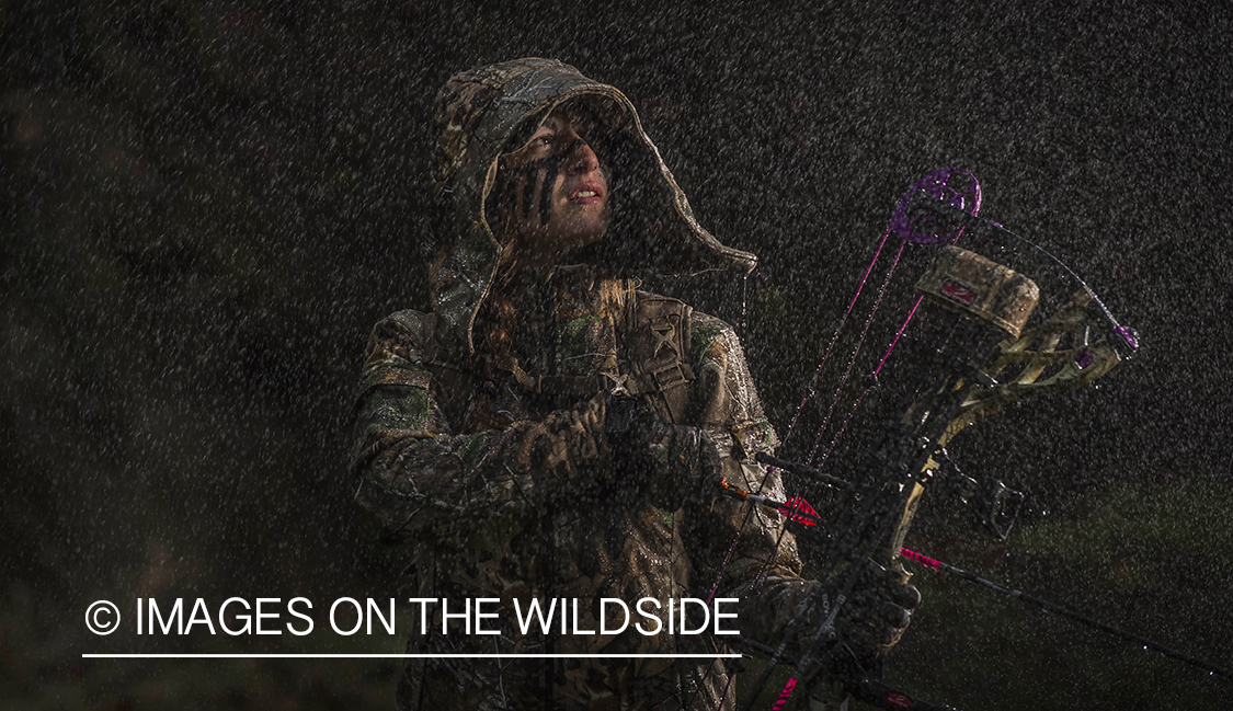 Woman bowhunting in the rain.