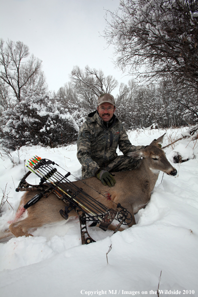 Archery hunter with bagged white-tailed doe. 