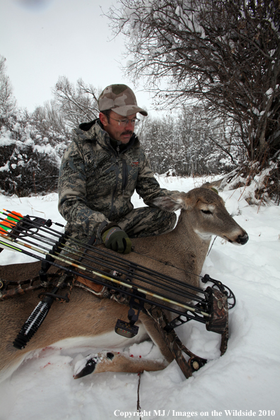 Archery hunter with bagged white-tailed doe. 