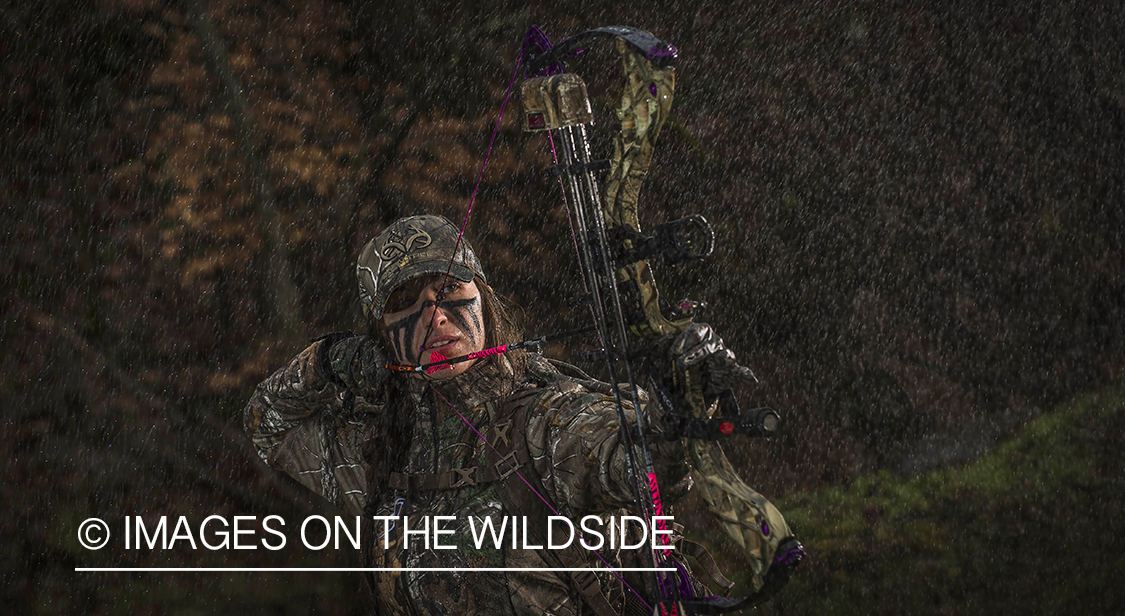Woman bowhunting in the rain.