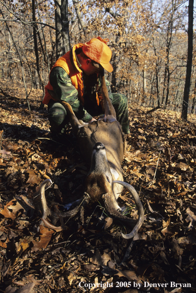 Young hunter with whitetail deer in truck.  Excited brothers chasing truck.