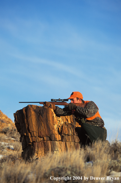 Big game hunter aiming/shooting.