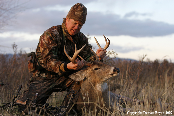 Bowhunter with whitetail buck kill.