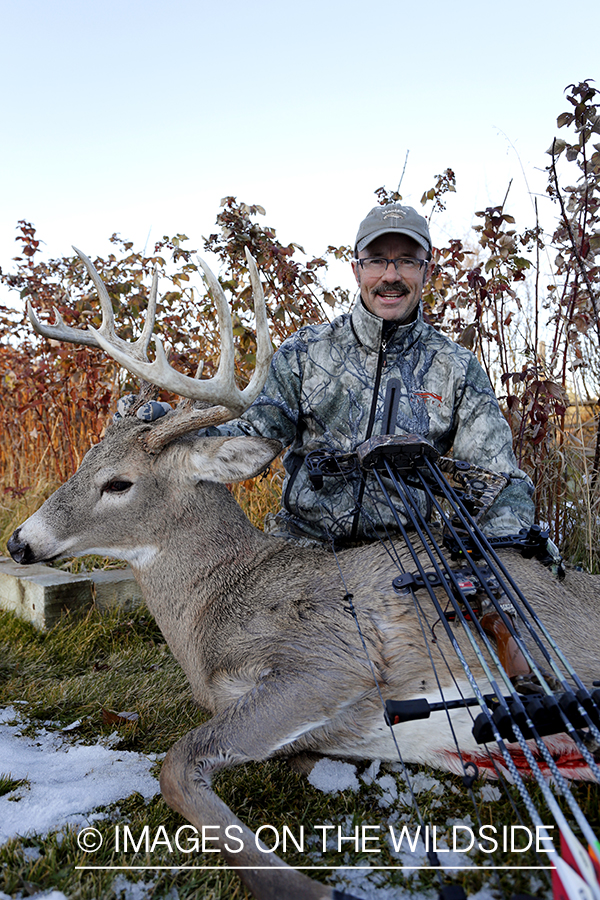 Archery hunter with downed White-tailed buck.