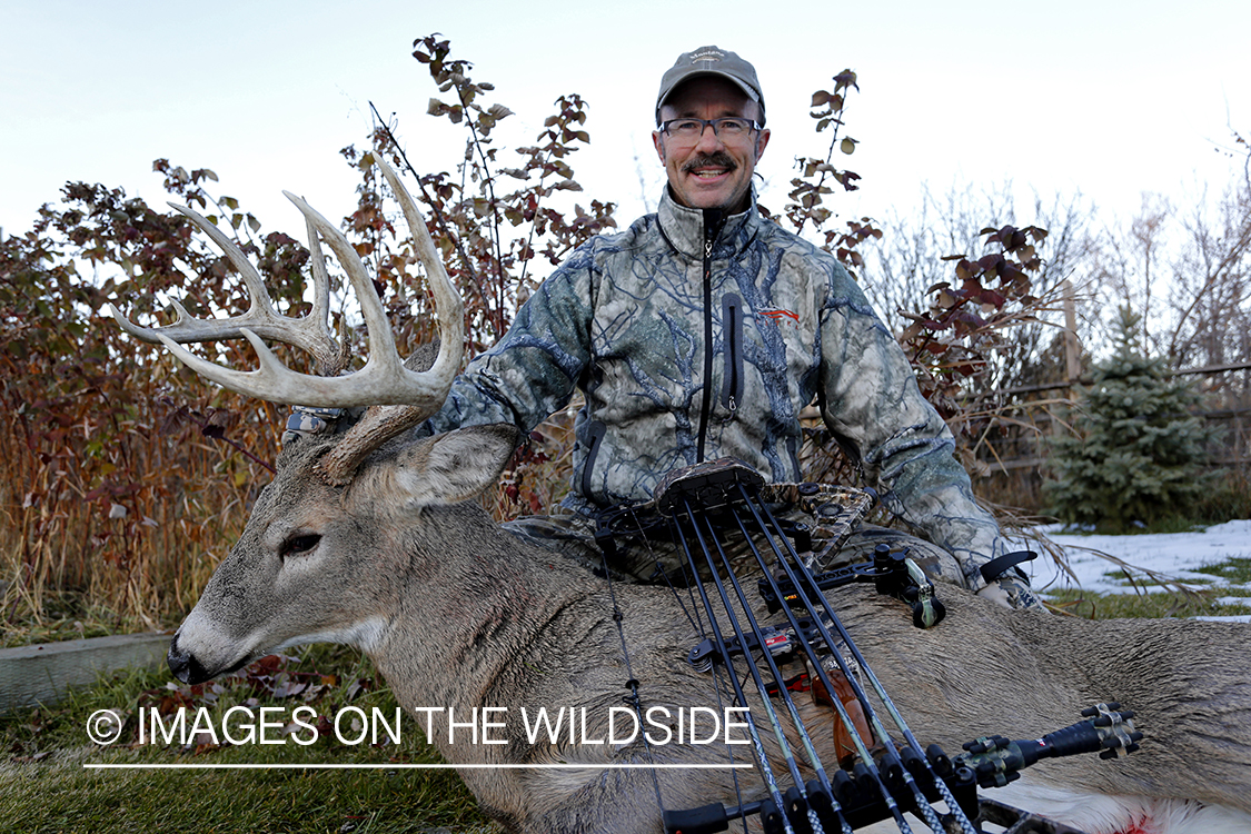 Archery hunter with downed White-tailed buck.