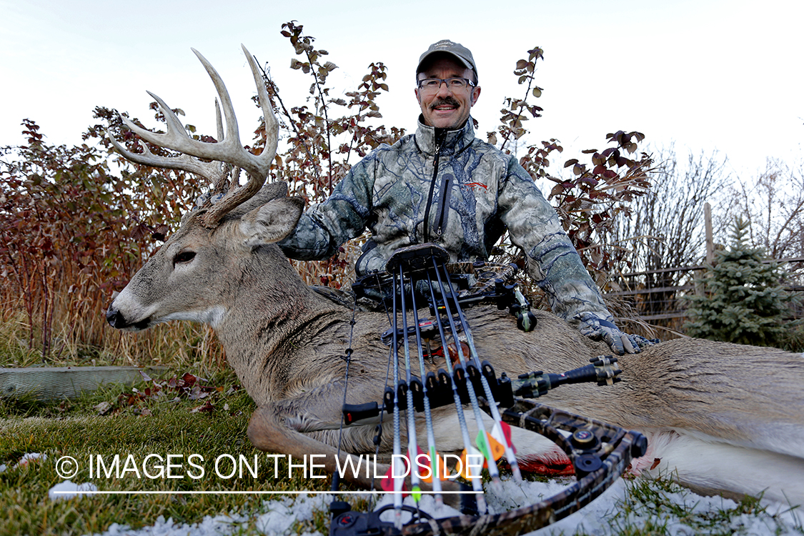 Archery hunter with downed White-tailed buck.