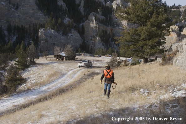 Big game hunter walking down jeep trail.