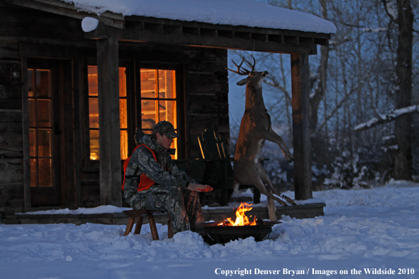 White-tailed deer hunter warming hands by campfire.