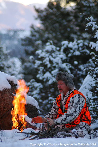 Big Game hunter by fire in the snow
