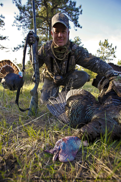Hunter with bagged (Merriam's) turkey - decoy in bakcground