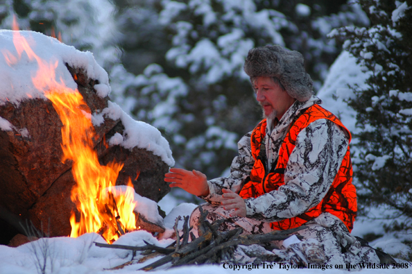 Big Game hunter by fire in snow