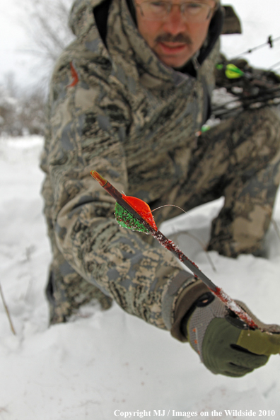 Archery hunter with passed-through arrow. 