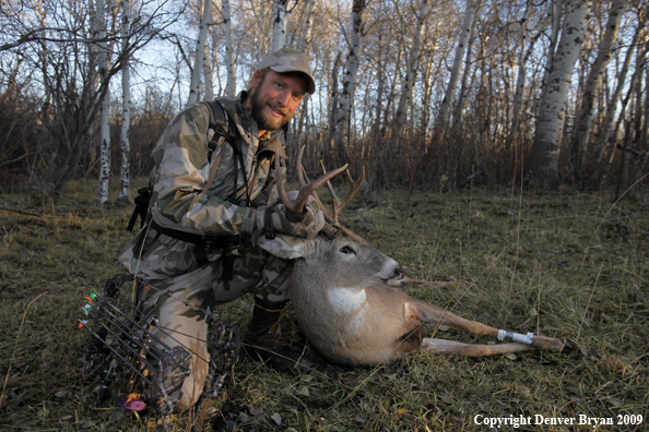 Bowhunter with bagged whitetail buck.