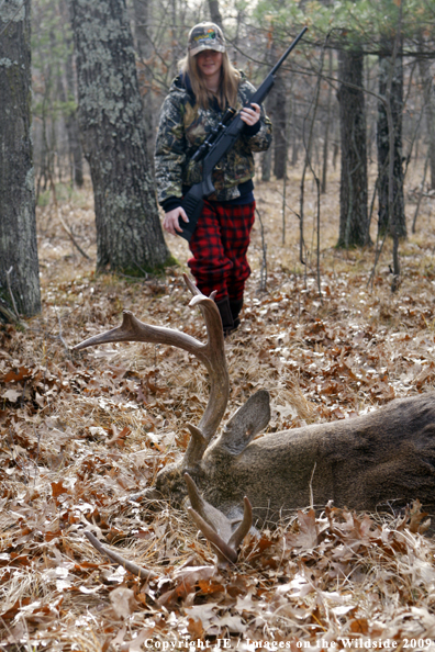 Young hunter approaching whitetail buck.