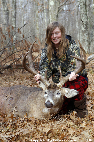 Young hunter with bagged whitetail buck.