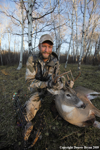 Bowhunter with bagged whitetail buck.