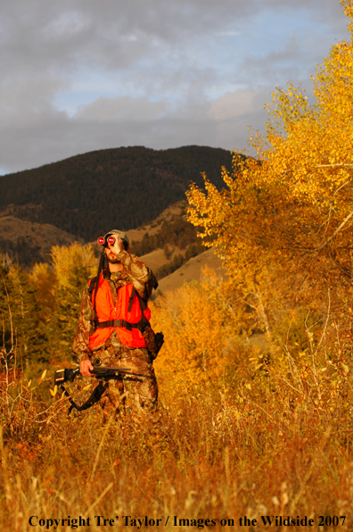 Big game hunter in field glassing