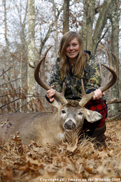 Young hunter with bagged whitetail buck.