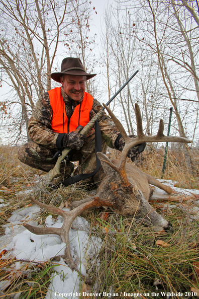 Hunter with bagged white-tailed buck. 