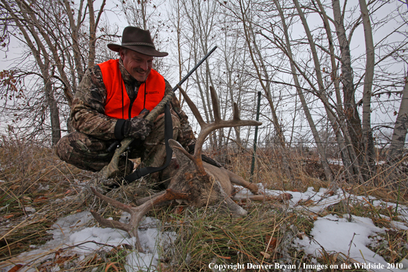 Hunter with bagged white-tailed buck. 